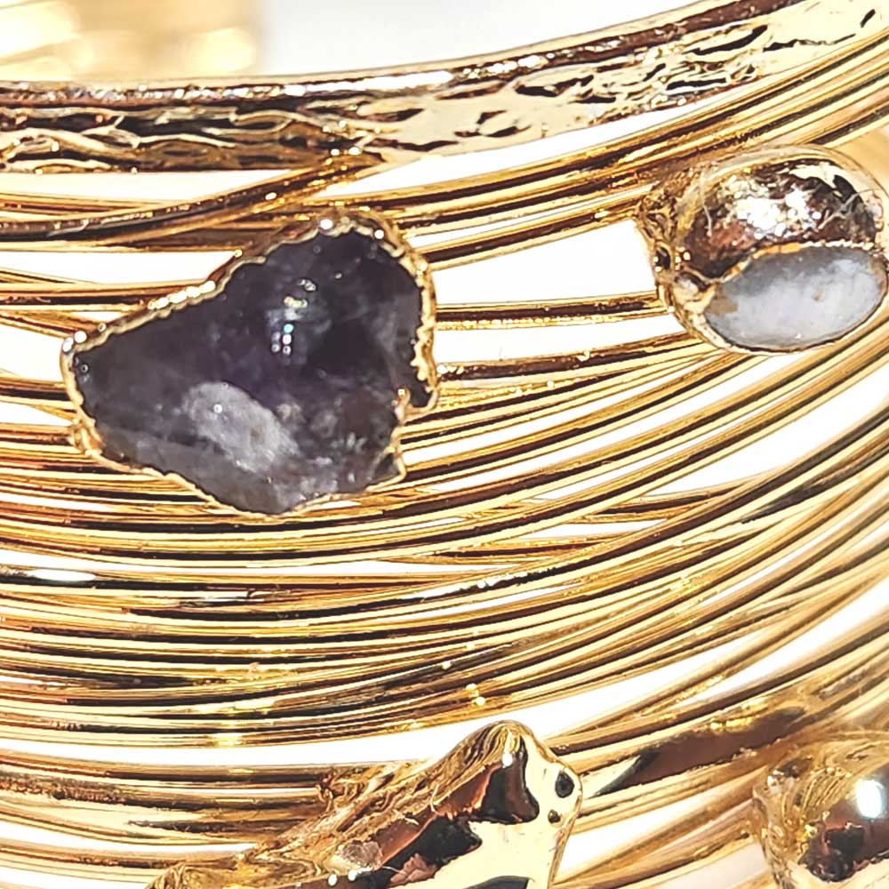 Close-up of the polished amethyst crystals and the rich gold-plated wire work on the bracelet.
