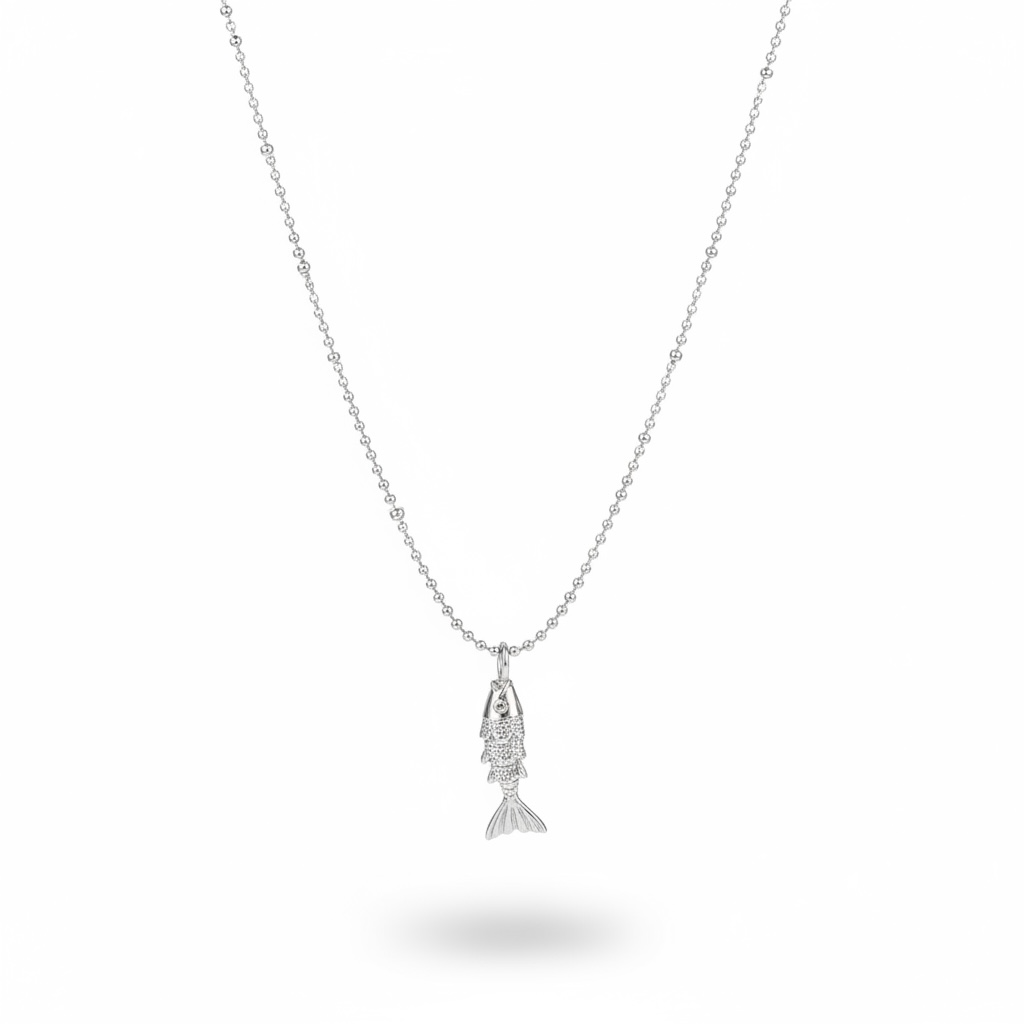 A silver ball-chain necklace with a small fish pendant, shown against a plain white background with a soft shadow underneath.