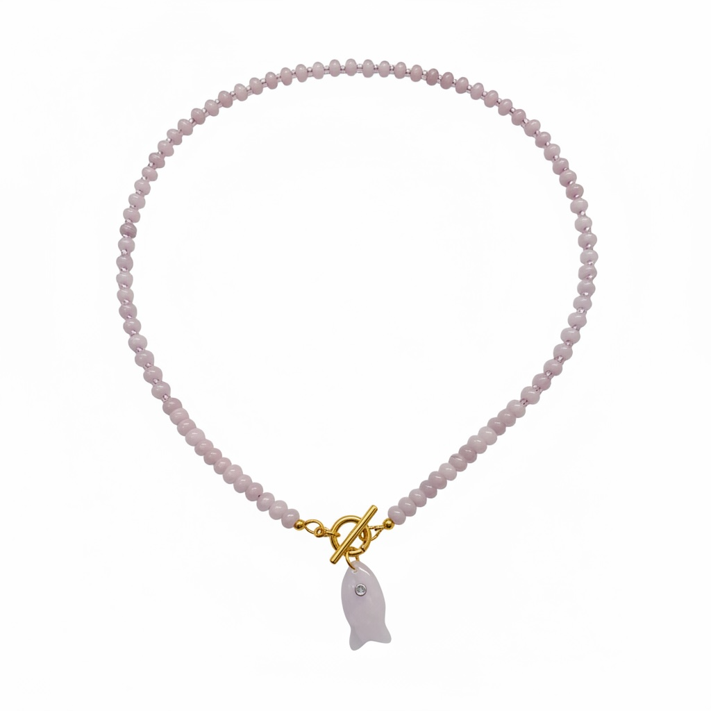 A delicate necklace made of small pale pink faceted beads, featuring a gold toggle clasp and a small fish-shaped pendant in a matching pale pink stone.