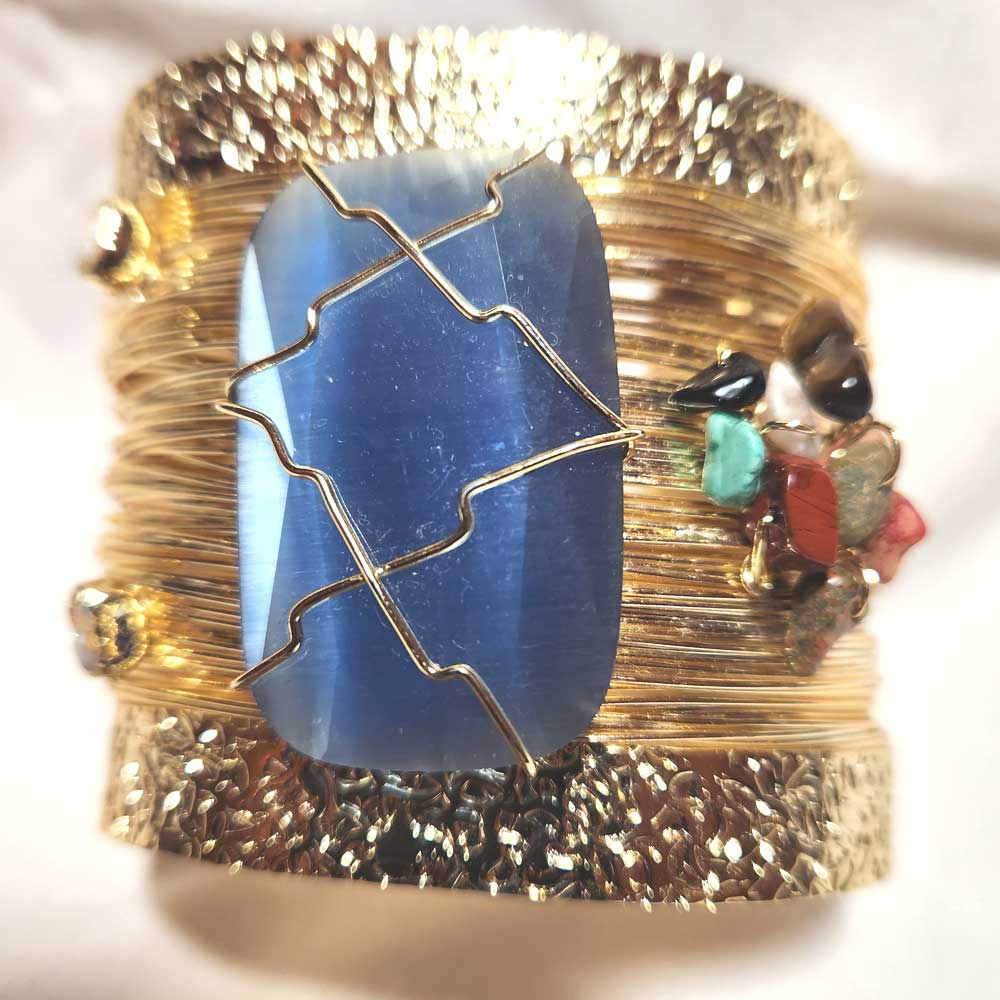 Close-up of the polished blue agate centerpiece on the gold cuff bracelet. Big gemstone