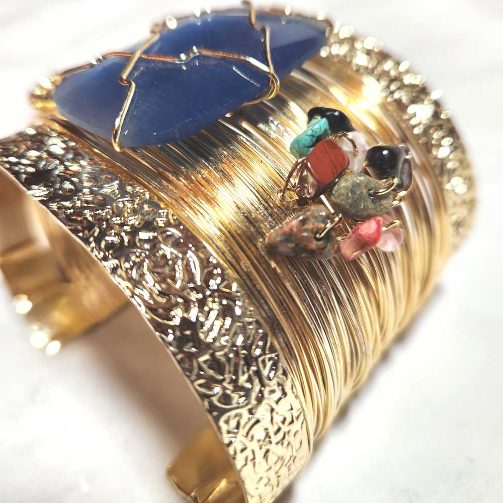 Close-up of the polished blue agate centerpiece on the gold cuff bracelet.