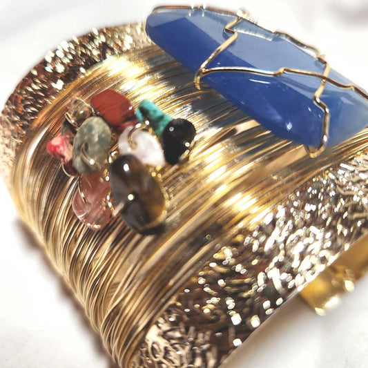 Close-up of the polished blue agate centerpiece on the gold cuff bracelet.