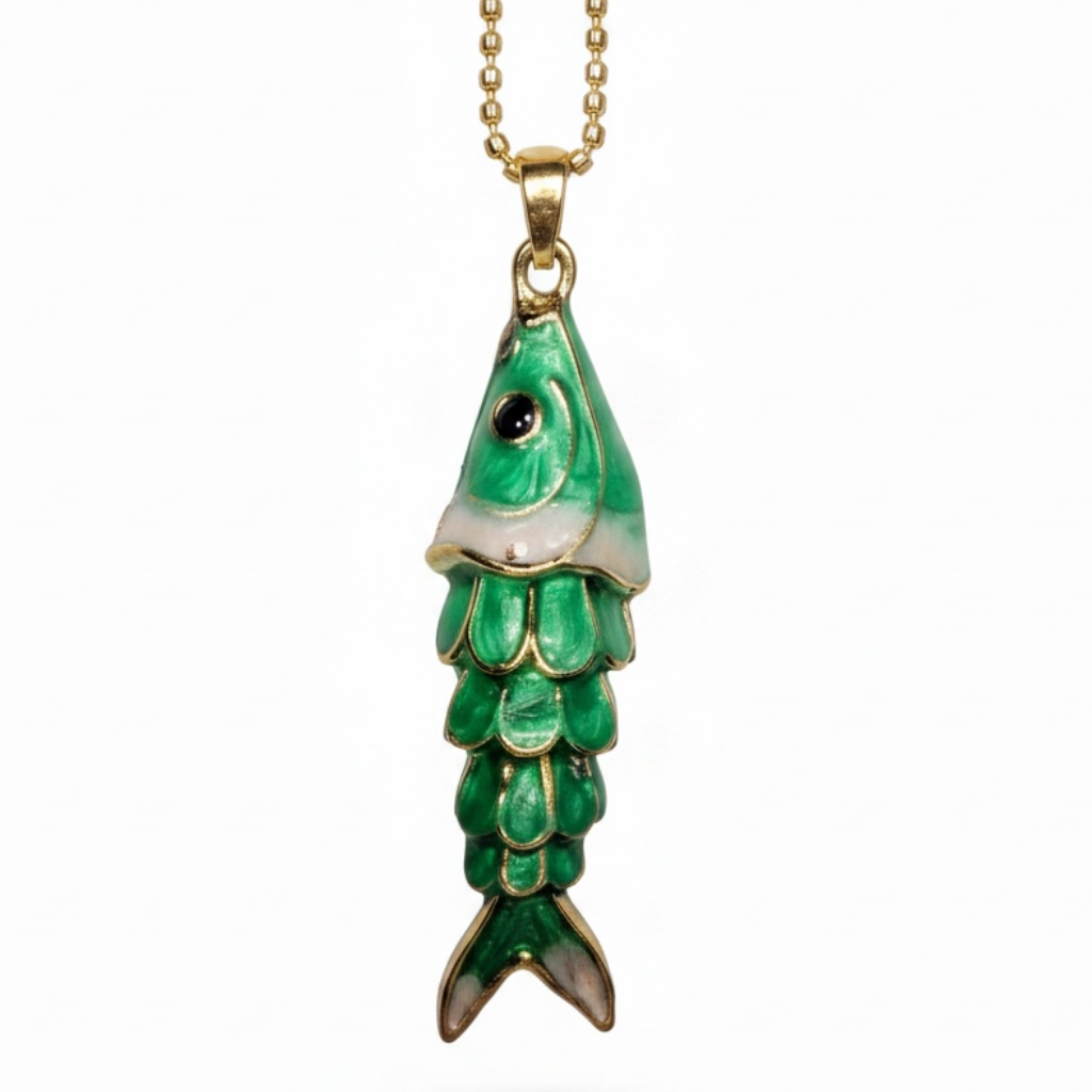 A gold chain necklace with a fish-shaped pendant featuring green enamel scales, a white belly, and a black eye, shown against a plain white background.